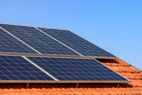 Toiture résidentielle équipée de panneaux solaires photovoltaïques sous ciel bleu dégagé