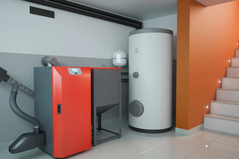 Sous-sol moderne avec installation de chauffage domestique comprenant chaudière rouge avec panneau de contrôle numérique, ballon d'eau chaude cylindrique blanc vertical, réseau de tuyauterie grise apparente et conduits d'évacuation