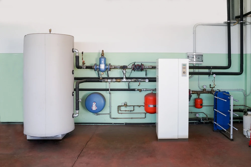 Local technique avec chaudière cylindrique blanche, système de chauffage central