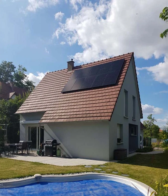 Deux techniciens installent des panneaux solaires photovoltaïques sur une toiture résidentielle en tuiles