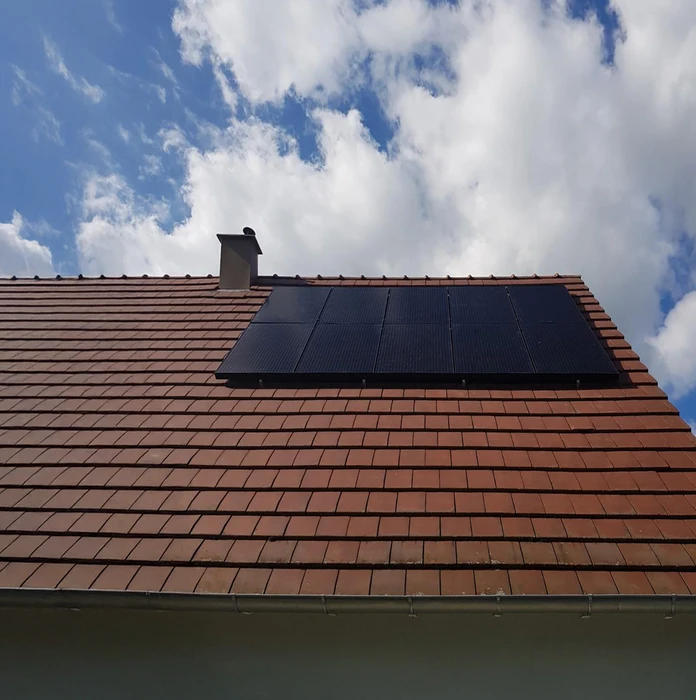 Technicien de panneaux solaires avec forage installant des panneaux solaires sur le toit de la maison par une journée ensoleillée